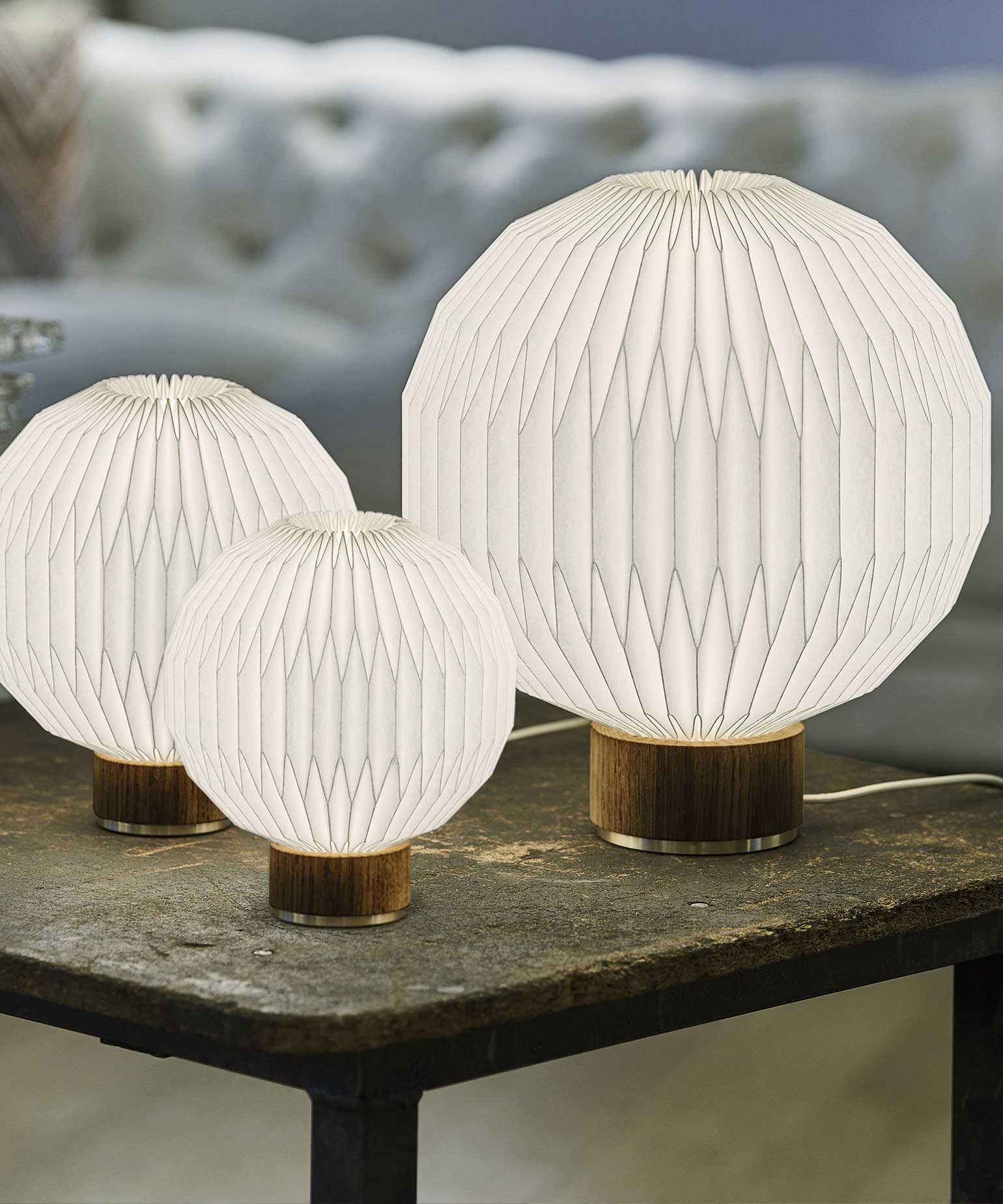 3 tændte bordlamper stående på et lille sidebord i en stue